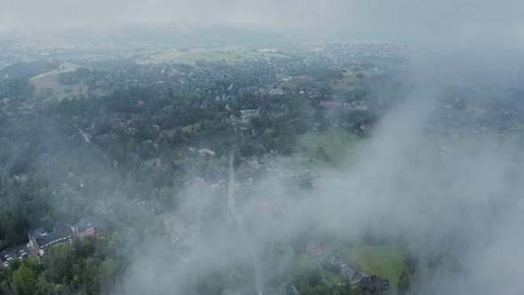 Video From a Drone a View of a City Located in a Spruce Forest Near a Field alt