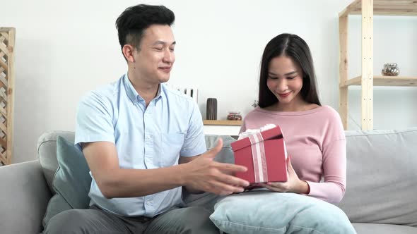 husband giving Gift his wife makes surprise. beloved man hold giftbox express gratitude for gift at