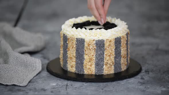 Unrecognizable Woman Pastry Chef Decorates Cake with Poppy Seeds