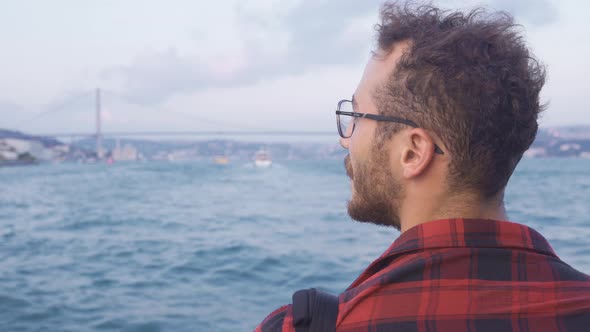 Man traveling on a ferry against the Bosphorus view. Istanbul city. alt