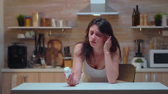 Wife with Headache Holding Pills Bottle alt