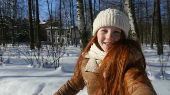 Happy Teen Girl Spinning In Winter Park. POV. Redhead Teenage Girl, Child Having Fun On Winter Walk