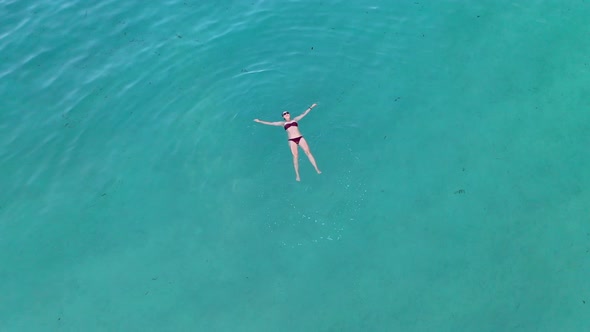 Young woman swimming in crystal clear ocean