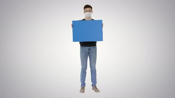 Student in Medical Mask Holding Blank Placard on Gradient Background. alt