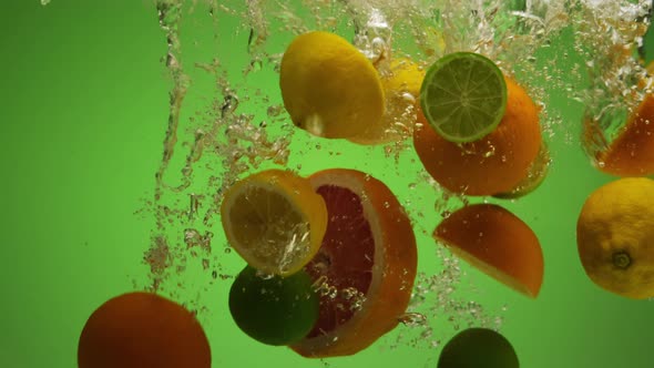 Mix of Exotic Citrus Fruits Falling Into Water in Slow Motion  Orange Lime Grapefruit Lemon alt