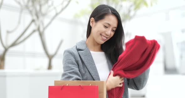 Woman picking out from paper bag after shopping alt