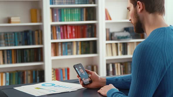 Young profesisonal male working with smartphone indoors alt