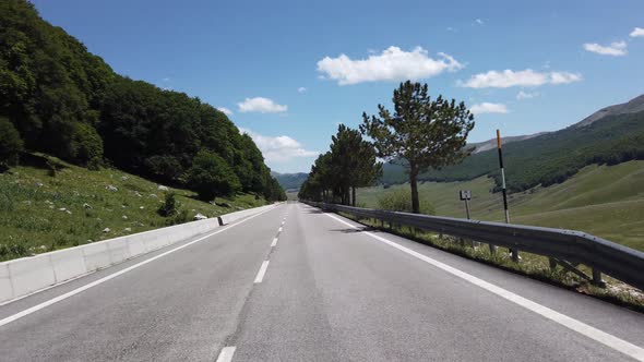 Moving view (car, motorbike or bicycle) of a mountain landscape