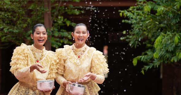 Young beautiful women enjoy to splashing water on Songkran festival alt