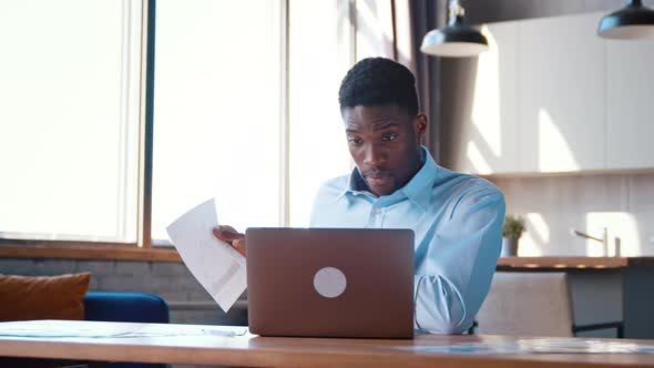 Young businessman in shirt showing his projects to colleague via video call remotely alt