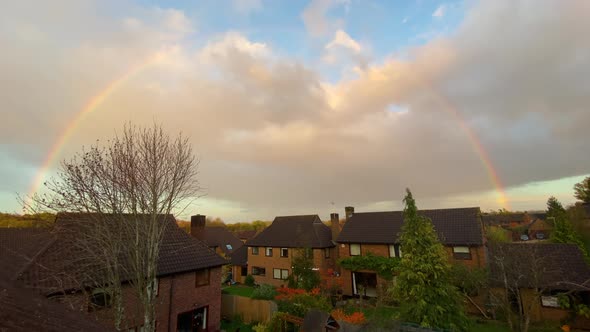 Wide shot: rainbow over English suburban town houses