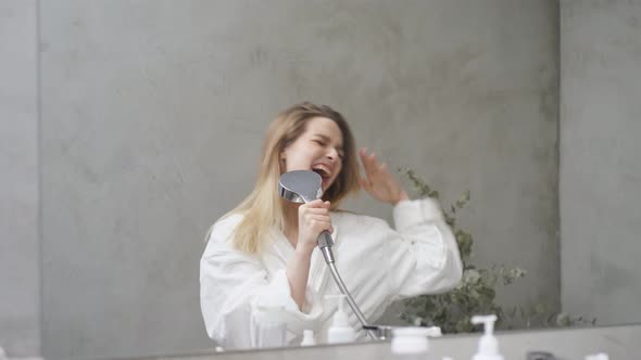 Adult Blonde Woman Singing in Bathtub Using Shower Head Having Fun Alone After Shower