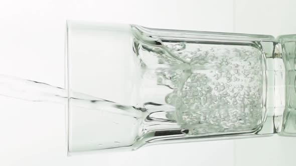 Vertical Video Crystal Clear Water Pouring Into Faceted Glass