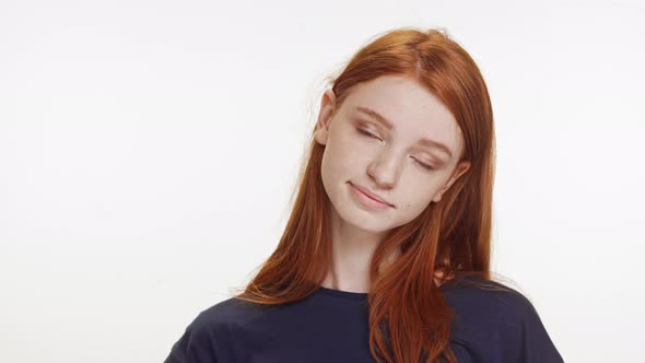 Smiling Charming Caucasian Teenage Ginger Girl in Dark Blue Tshirt Standing on White Background alt