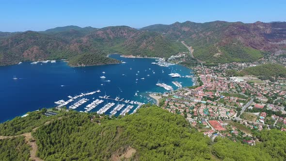 Small City Houses, Beautiful Marina and Touristic Boats in a Cove Surrounded by Forest by Sea alt