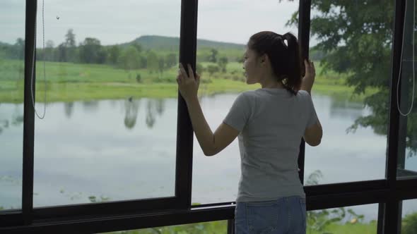slow-motion of woman open window and looking to nature view