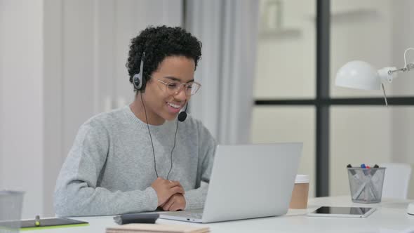 African Woman Using Headset for Video Chat on Laptop  alt