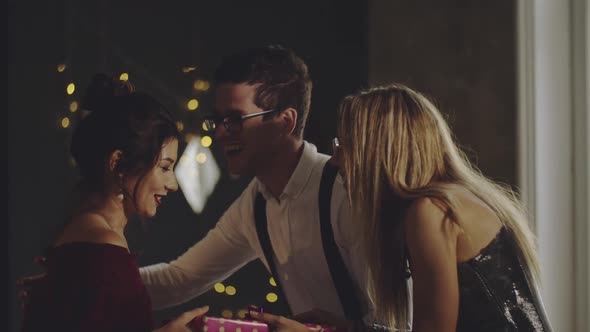 Joyful Woman Greeting Friends with Hugs and Handshakes Receiving Gifts Wrapped in Paper for Birthday alt