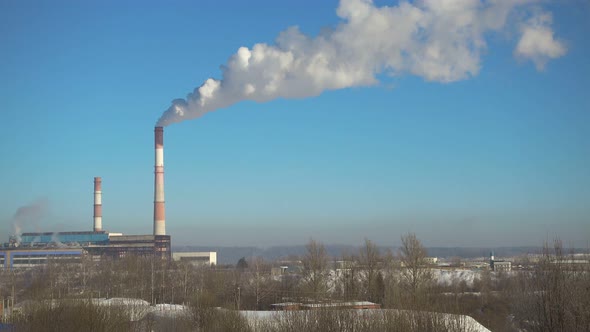 Time Lapse, Pipes with Smoke of Thermal Power Station in Winter at Beautiful Sunny Day.