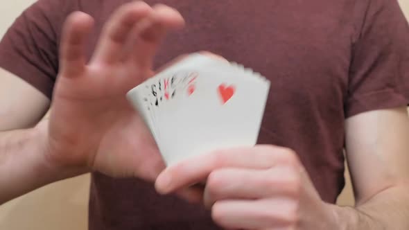 A Young Magician Makes a Fan From a Deck of Cards Showing a Magic Trick