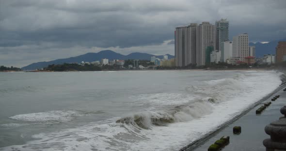 Cloudy Weather, Rain, Large Gray Clouds, Gloomy Weather, Sea Waves Break on the Shore of the City alt