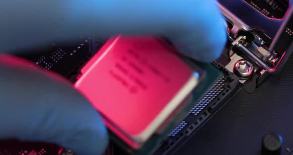 manipulating and installing processor on the motherboard in details with blur and selective focus alt