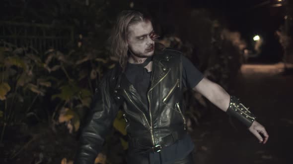 Angry Zombie Man with Bloody Face Walking Along Night Road alt