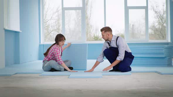 Master Man Together with Smiling Woman Insulate Floor with Expanded Polystyrene for Laying Laminate alt