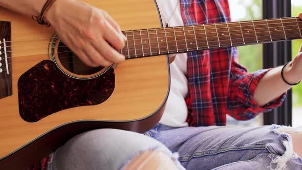 Young Man Playing Guitar Sitting on Windowsill alt