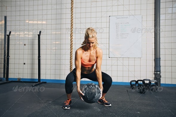 Woman doing crossfit workout with medicine ball at gym