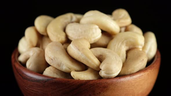 Cashews nuts in wooden bowl, rotation. Healthy vegan food concept
