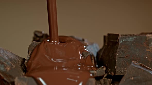 Super Slow Motion Shot of Pouring Melted Chocolate on Raw Chocolate Chunks at 1000 Fps. alt