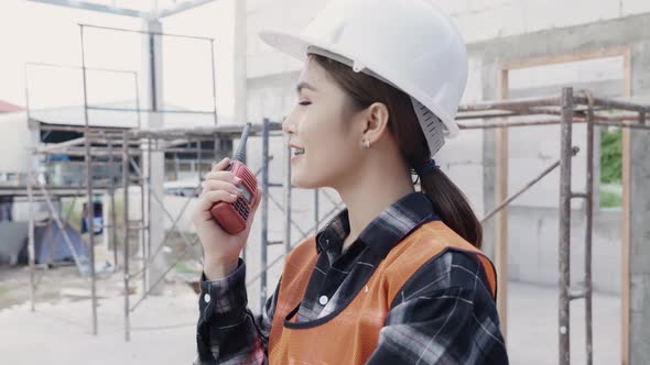 foreman architect worker woman working at building construction site talking with radio alt
