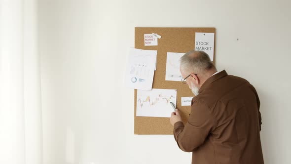 man examines the charts of the stock market alt