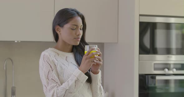 Woman drinking juice in kitchen