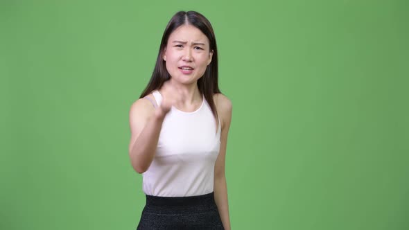 Young Angry Asian Businesswoman Talking To Camera
