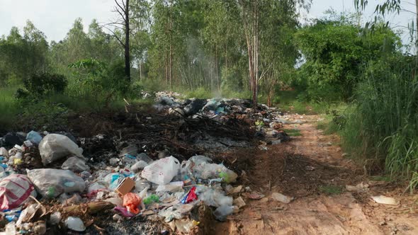 B roll of garbage dump in forest. Environment crisis. Garbage and fire burn.