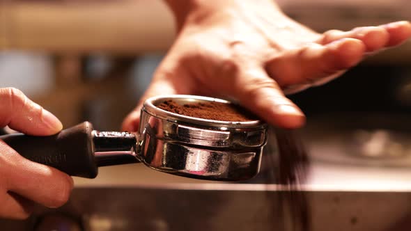 Barista hand holding portafilter for coffee grounds powder. Coffee Grounds Espresso