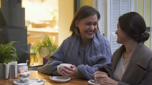Two Best Female Friends Having Good Time, Sitting in Cafe, Talking and Laughing alt