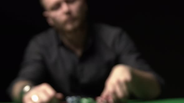 Man Doing a Bet Red Chips Scattering Over Green Table Towards