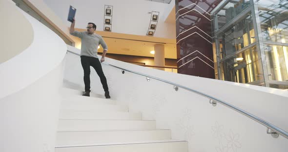 Happy Businessman Dancing on Stairs in Office Hall alt