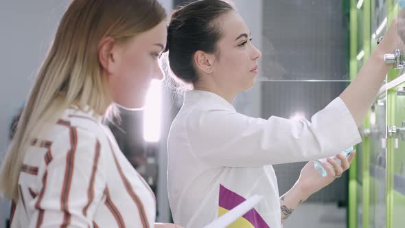 Pharmacist and Woman Choosing Medicine Near Trade Shelf alt