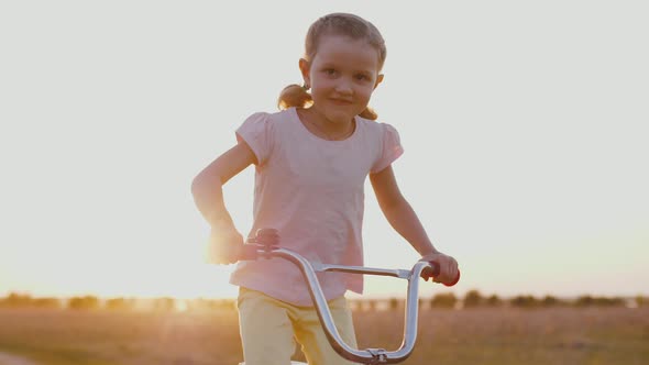 Cute Child Riding Bicycle at Sunset of Golden Sun Having Fun Outdoors on Nature alt