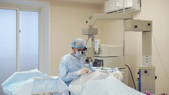 Alone Surgeon Is Sitting in Operating Room Near Table with Patient alt
