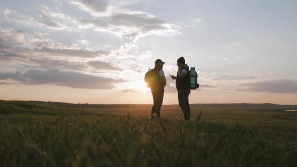 The Silhouette of Two Man on the Top of Mountain with Backpacks and Other Gear Expressing Energy and alt