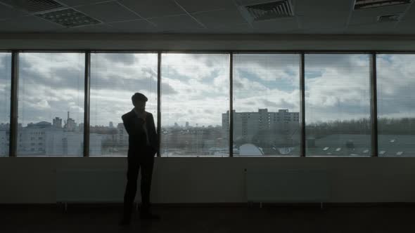 Waiting Process Businessman Walks in Front of a Panoramic Window Morning in a Modern Office Natural alt