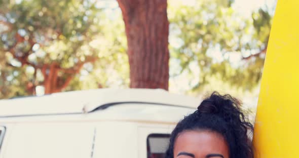 Smiling woman with surfboard standing near camper van 4k alt
