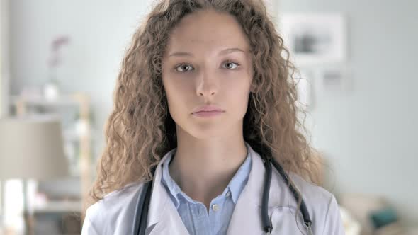 Young Lady Doctor in Clinic Looking at Camera alt