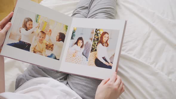 Hands Scroll Through Pages of Photobook alt