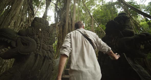 Young Explorer Walking Up the Stairs in an Ancient Temple and Admiring Sculptured Pillars in the alt